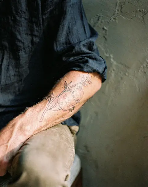 A pomegranate branch along a forearm