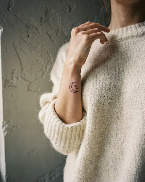 A small moon and stars on the inside of a wrist